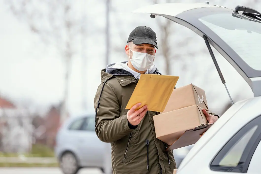 man holds a manila envelope and cardboard boxes 