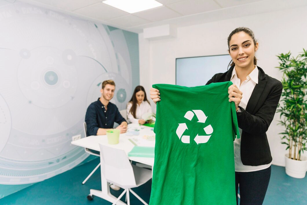 business attire holds up a green t-shirt with a recycling symbol