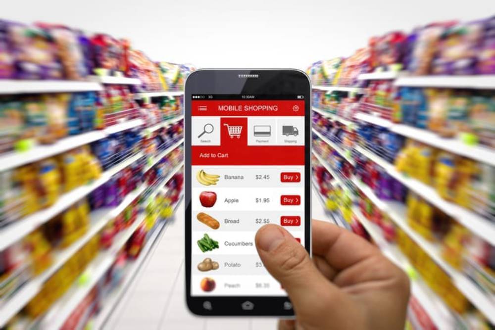 A hand holds a smartphone displaying a mobile shopping app